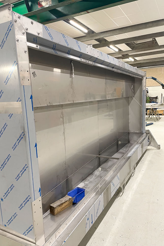 Washing machine for mobile benches in greenhouses